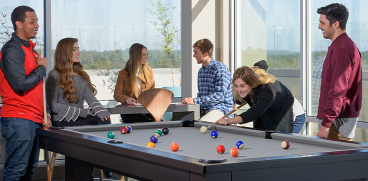 Group of young adults playing pool