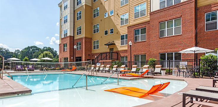 Campus View Apartments Resort Style pool with orange lounge chair