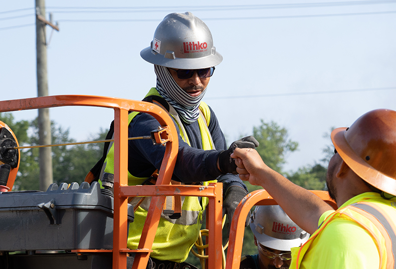 Construction team members fist-bumping