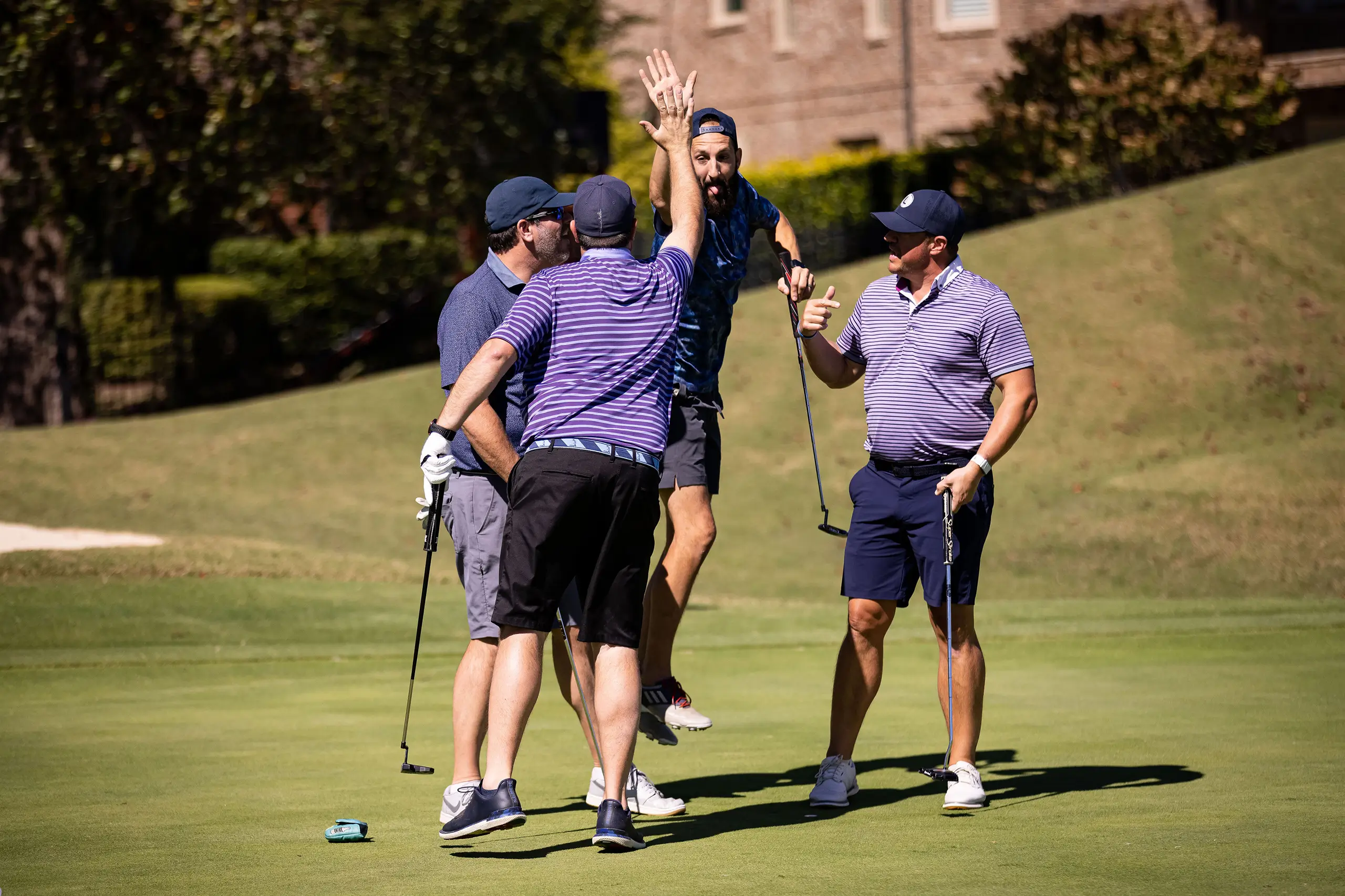 a group of men high-fiving while playing golf