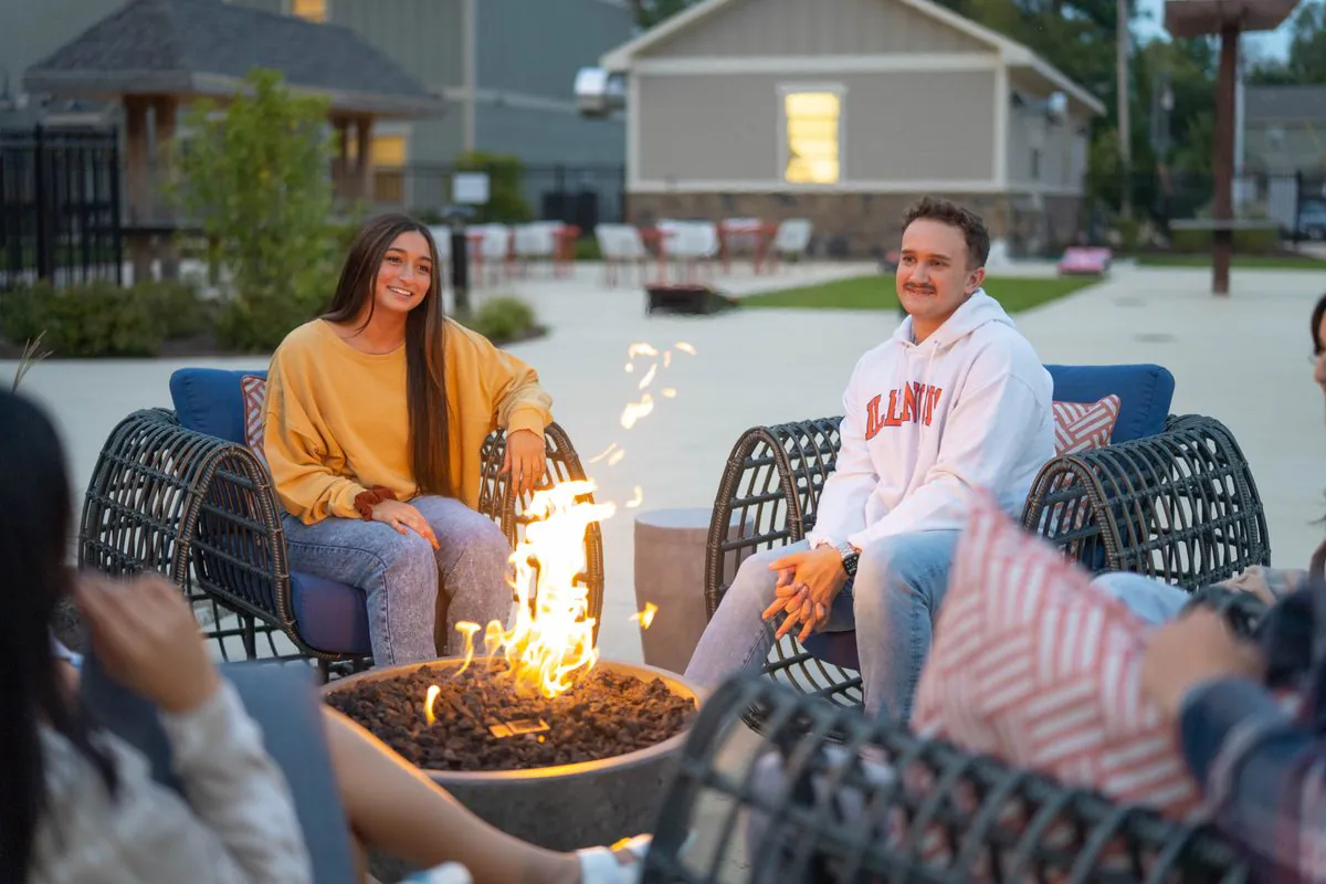 adults hanging out by a fire pit